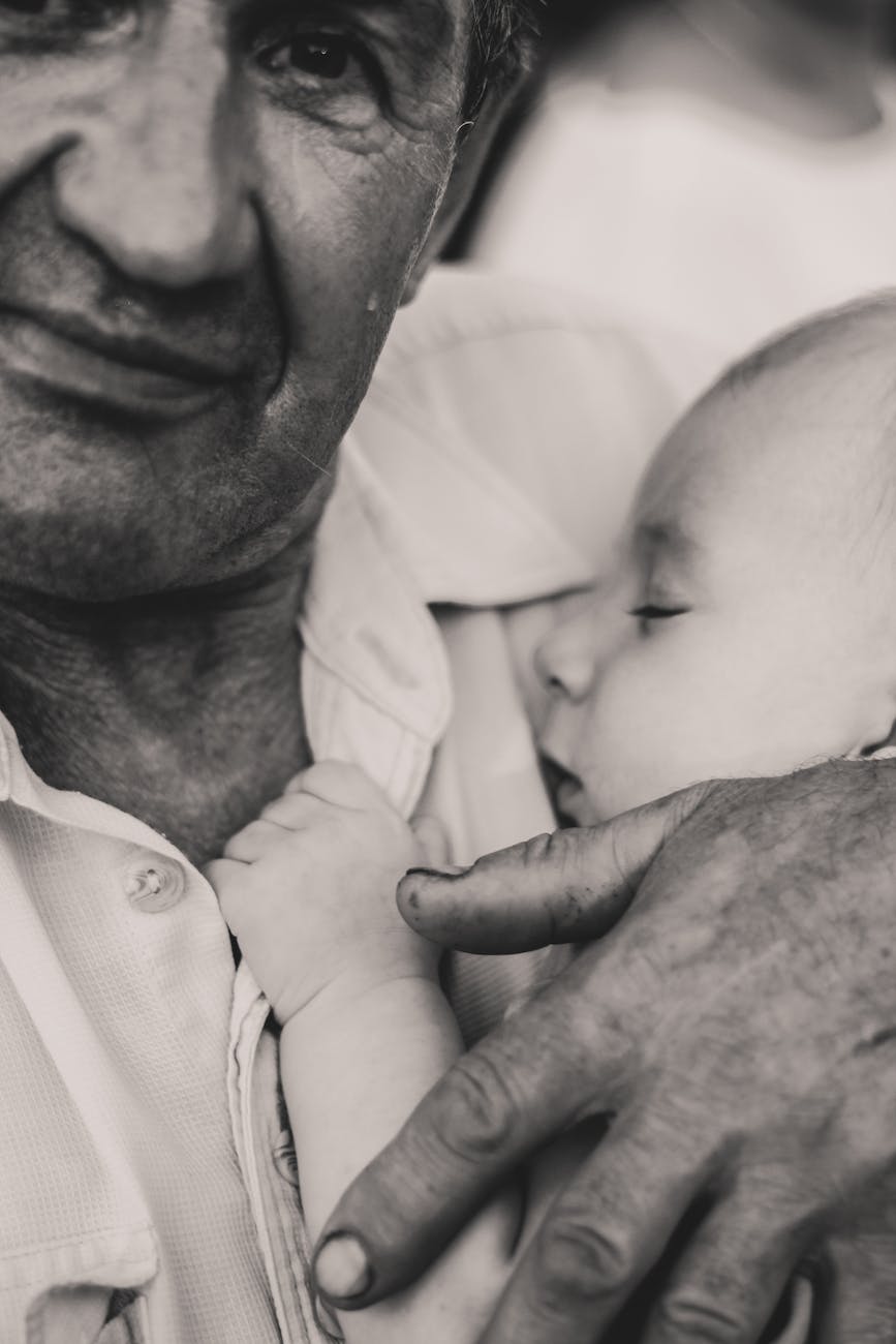 black and white portrait of man holding sleeping baby